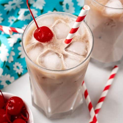 dirty soda recipe in a glass jar with a paper straw