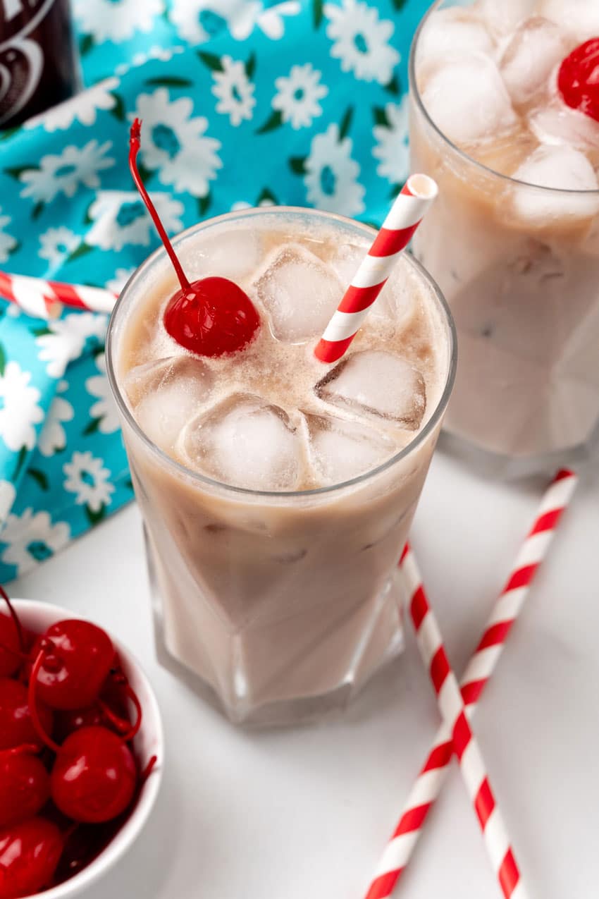dirty soda recipe in a glass jar with a paper straw