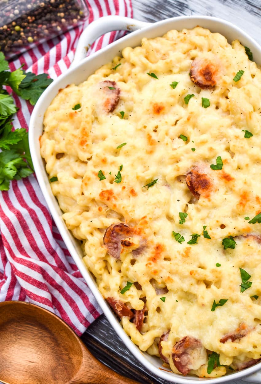baked alfredo pasta with sausage in a white casserole dish