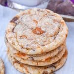 a stack of butterfinger cookies on a parchment paper lined baking sheet