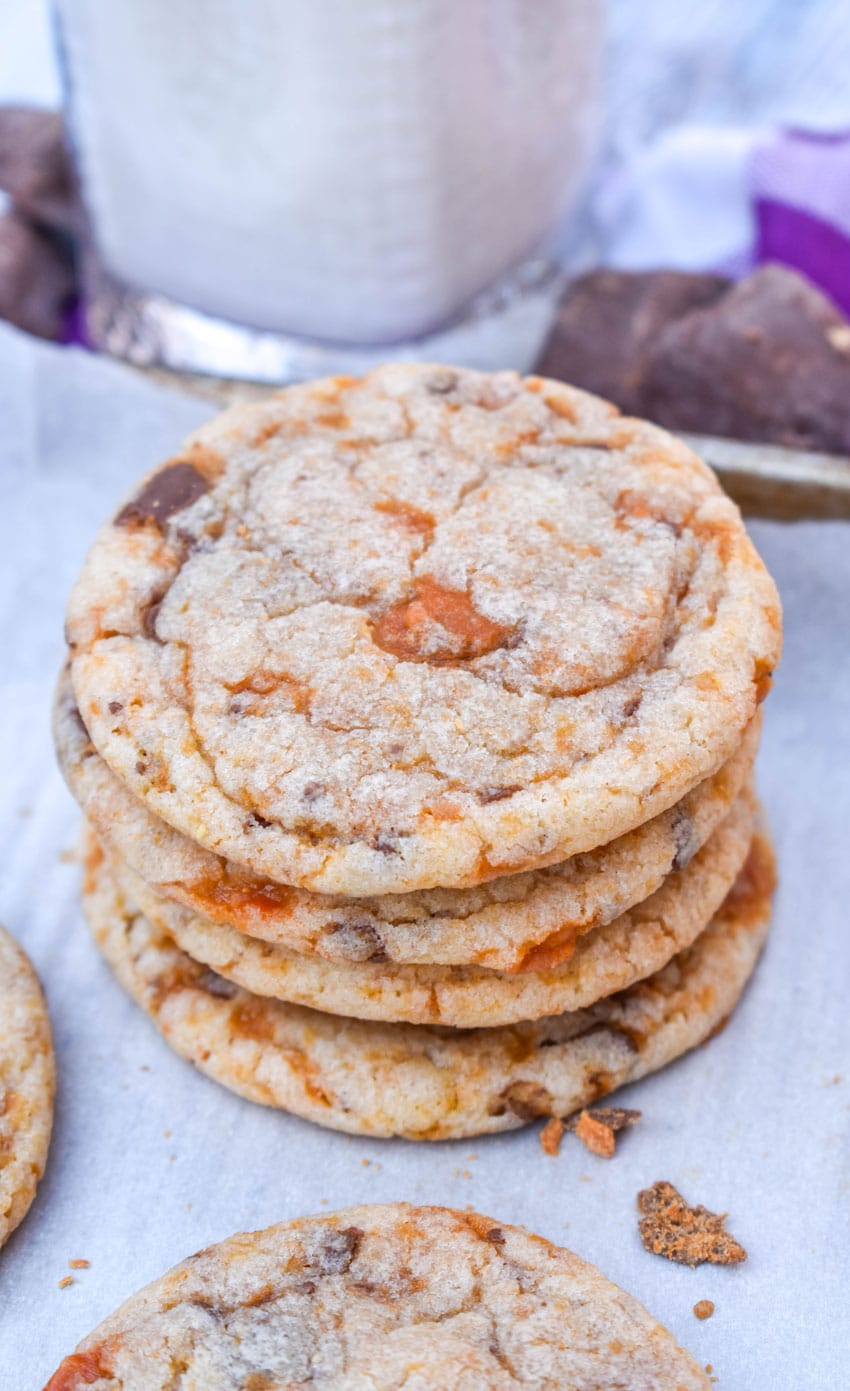 a stack of butterfinger cookies on a parchment paper lined baking sheet