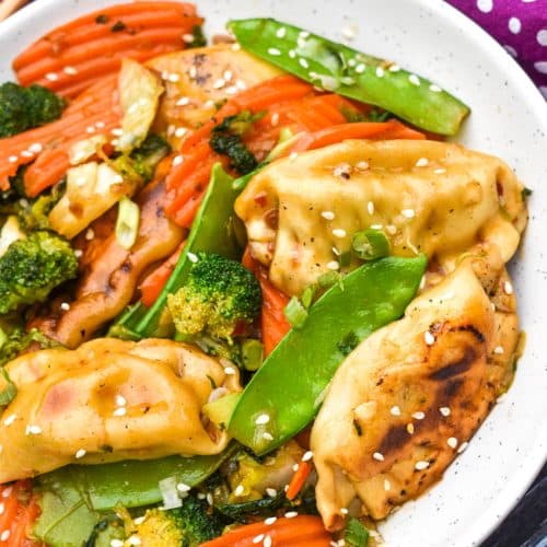 easy potsticker stir fry in a white bowl with wooden chop sticks on the side