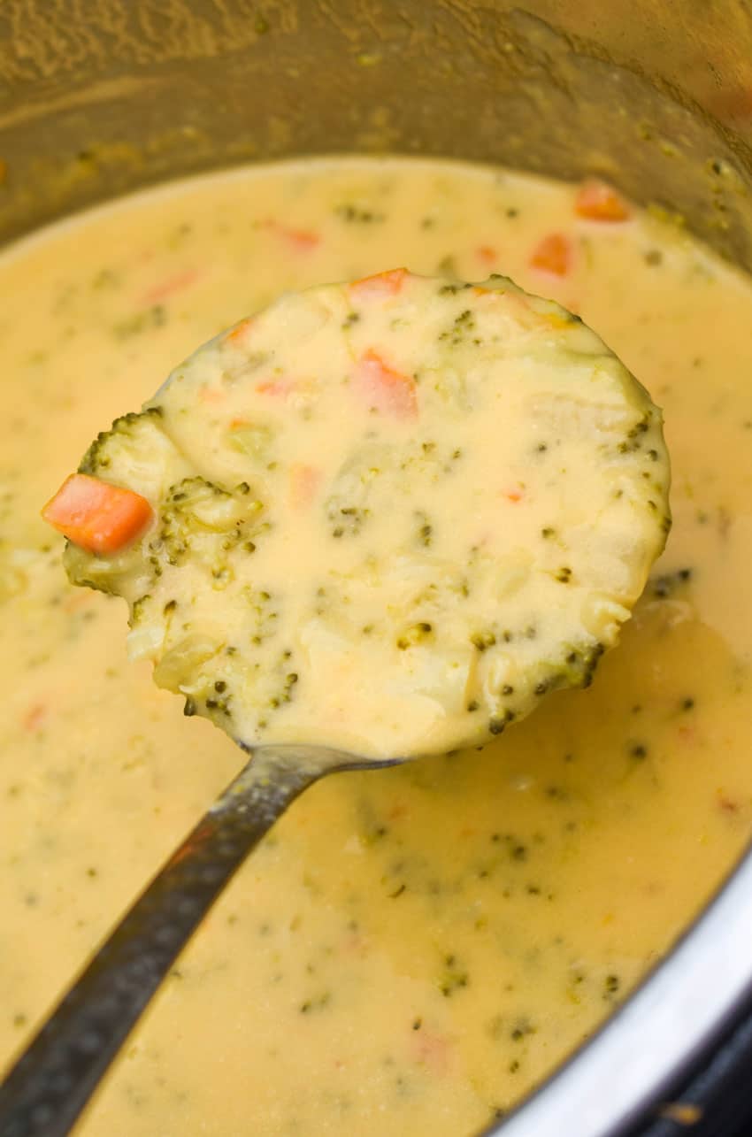 a silver ladle scooping broccoli cheddar soup out of the bowl of an instant pot