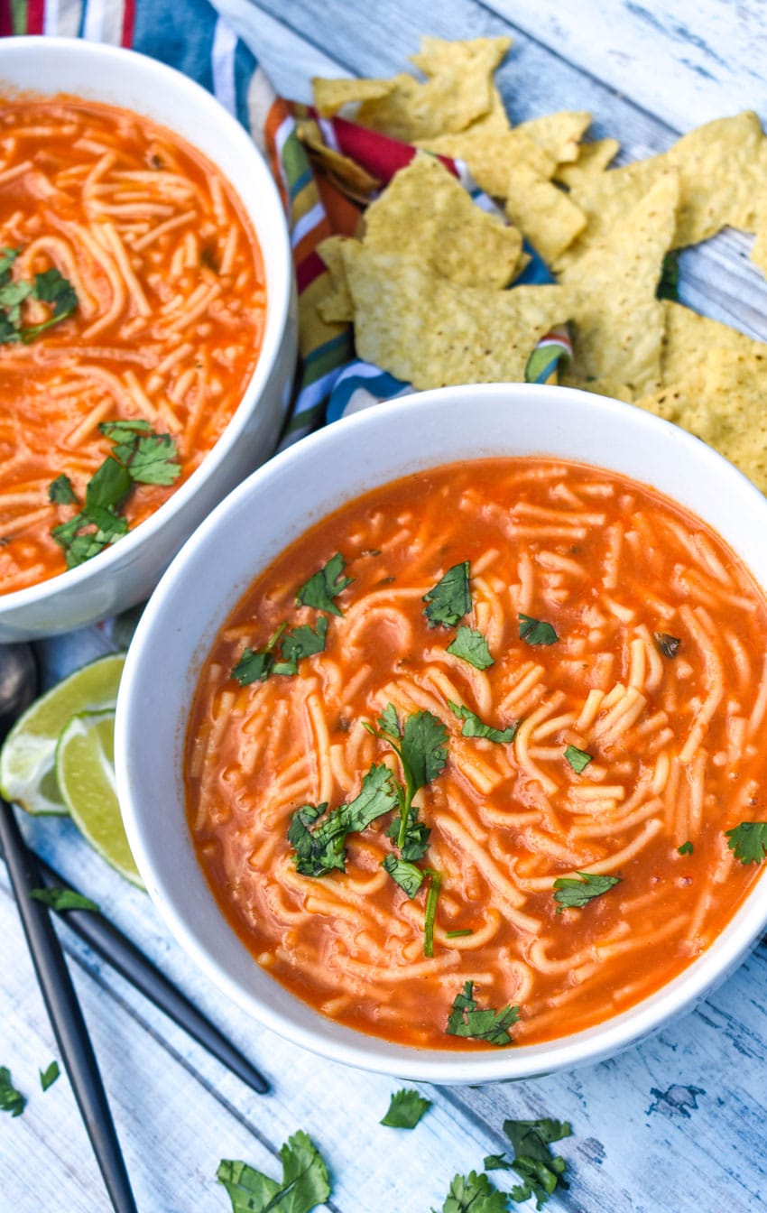 instant pot sopa de fideo topped with fresh cilantro leaves in two white soup bowls