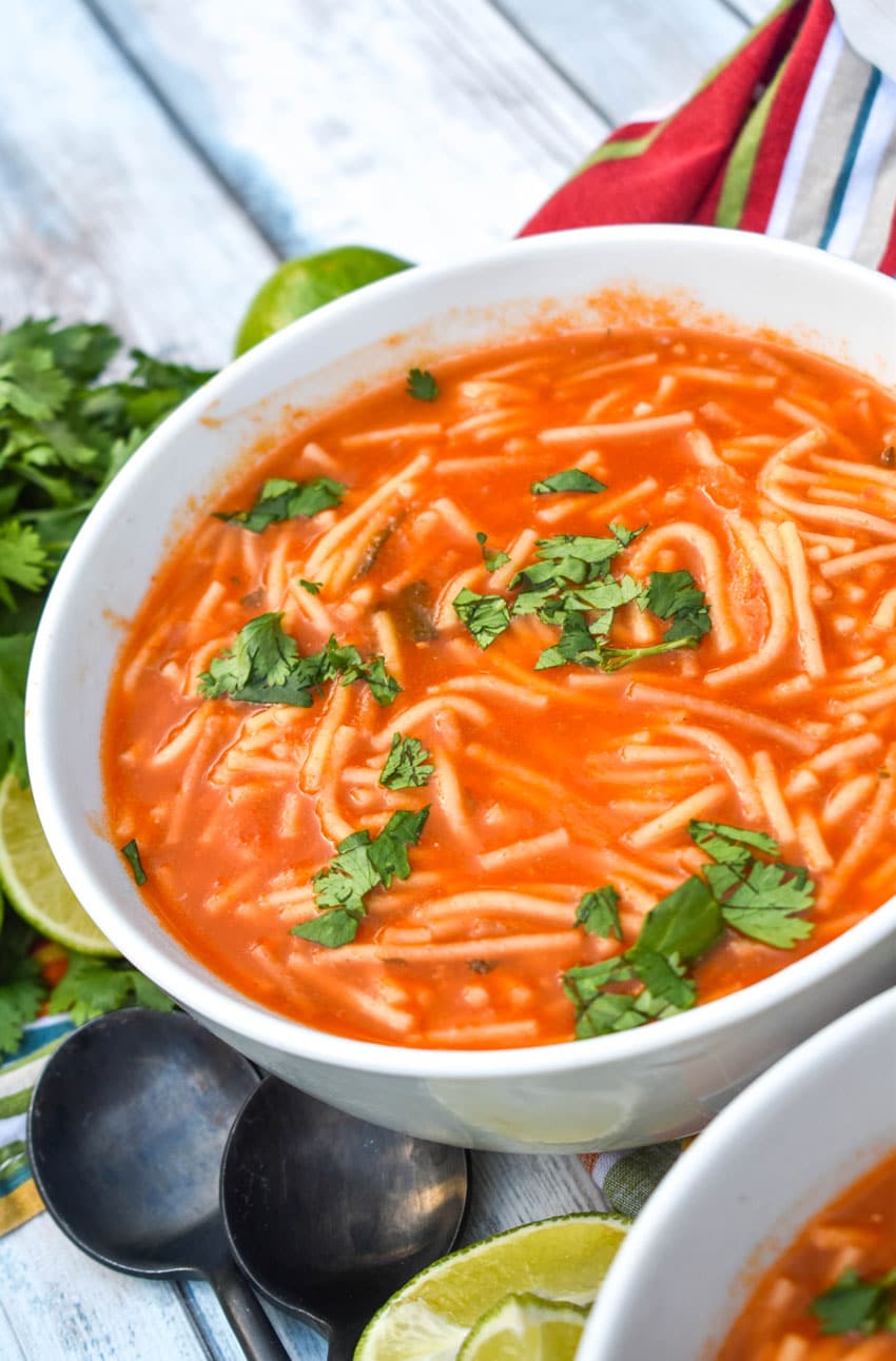 instant pot sopa de fideo topped with fresh cilantro leaves in two white soup bowls