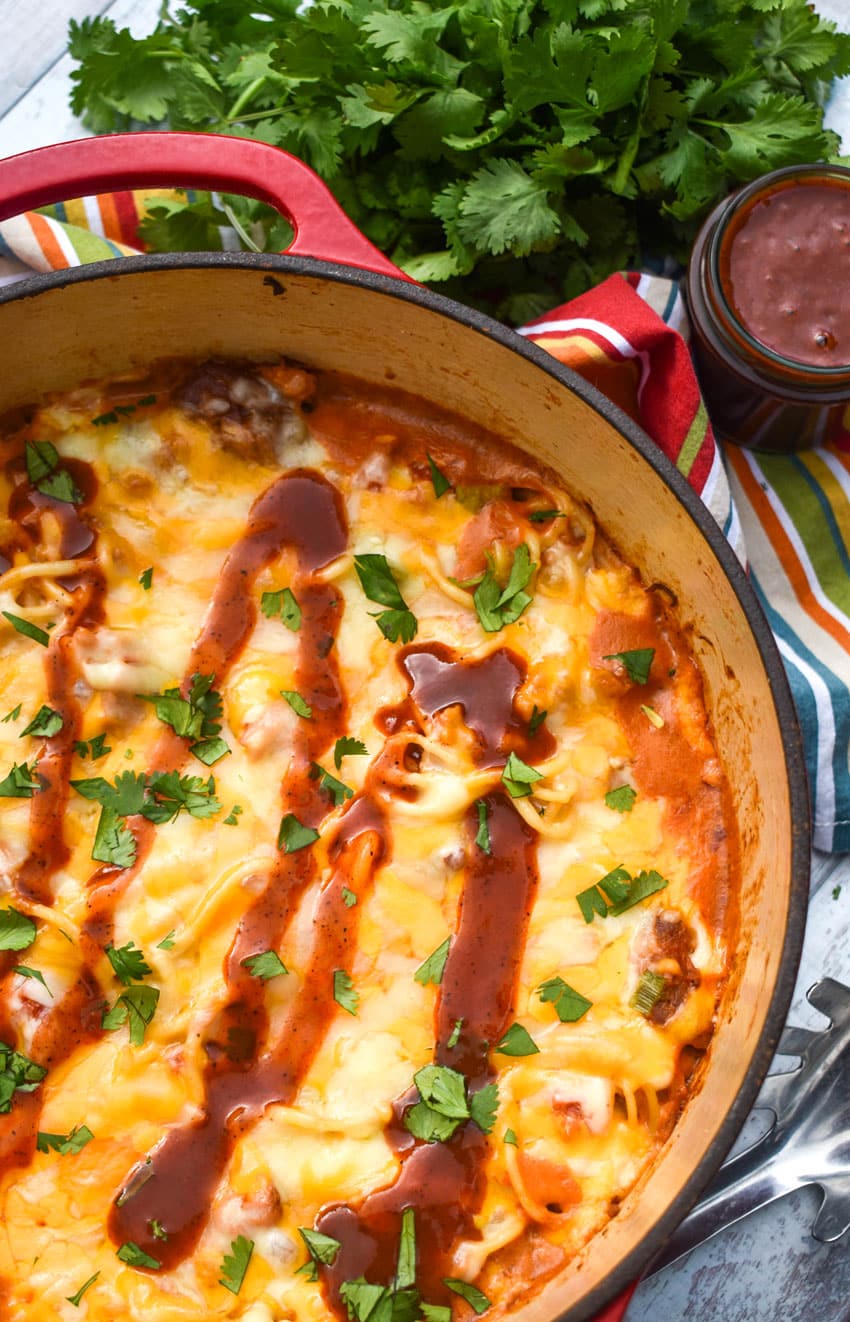 cheesy barbecue pulled pork pasta in a large cast iron pot