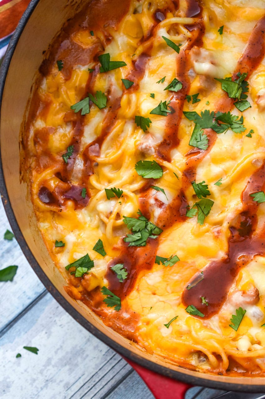 cheesy barbecue pulled pork pasta in a large cast iron pot