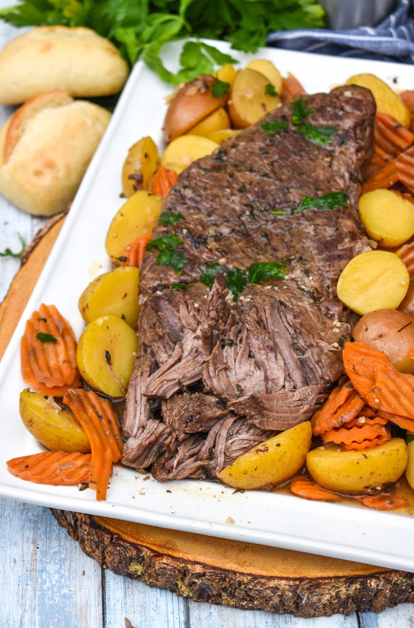 THE BEST SLOW COOKER POT ROAST SHREDDED ON A WHITE PLATTER