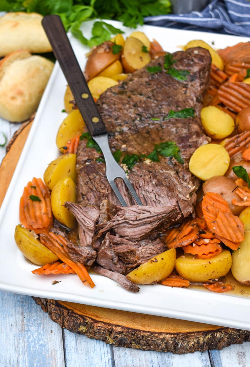 THE BEST SLOW COOKER POT ROAST SHREDDED ON A WHITE PLATTER