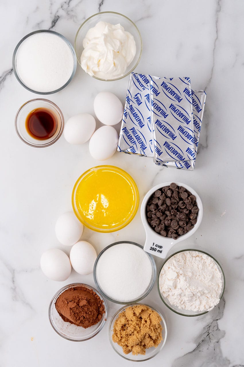 an overhead image showing the measured ingredients needed to make a brownie bottom cheesecake