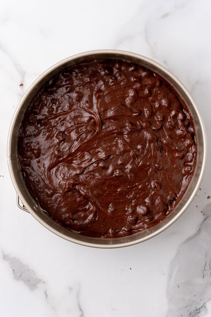 brownie batter in the bottom of a metal springform pan