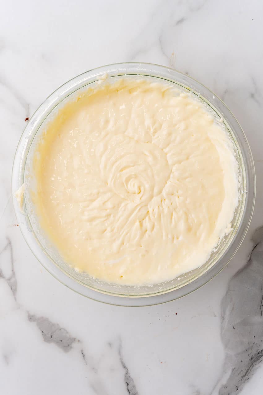 cheesecake batter in a glass mixing bowl