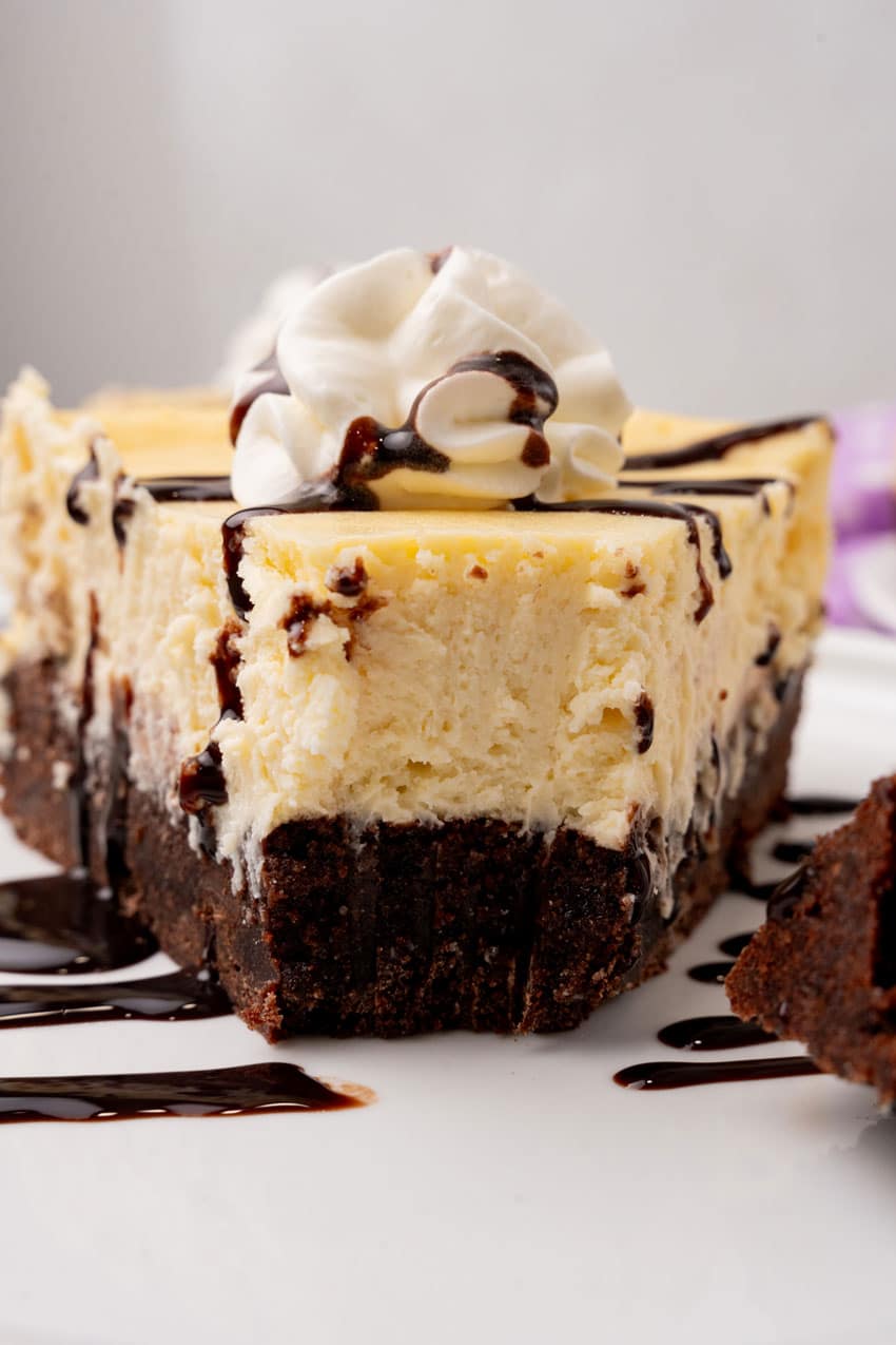 a slice of brownie bottom cheesecake on a white plate