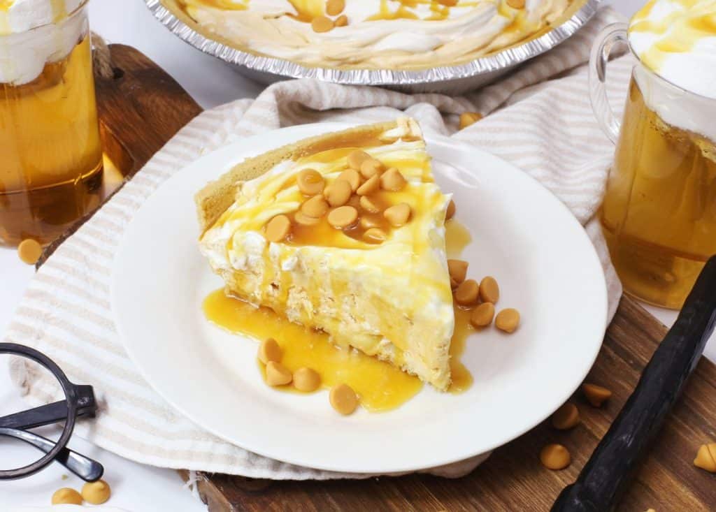 a slice of butterbeer pie topped with caramel sauce on a small white plate