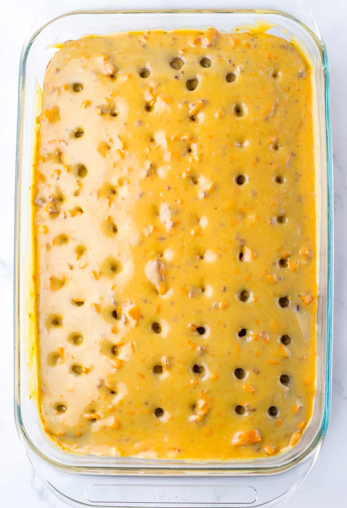peanut butter cream poured out over top of a baked chocolate poke cake
