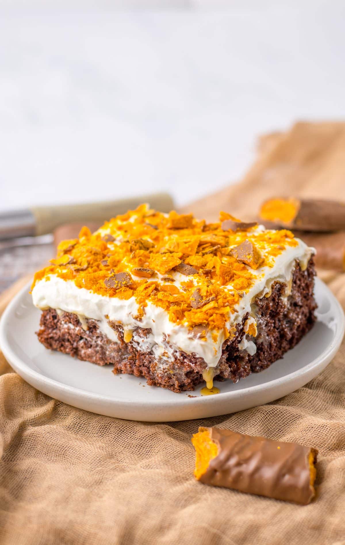 a slice of butterfinger poke cake on a small white plate