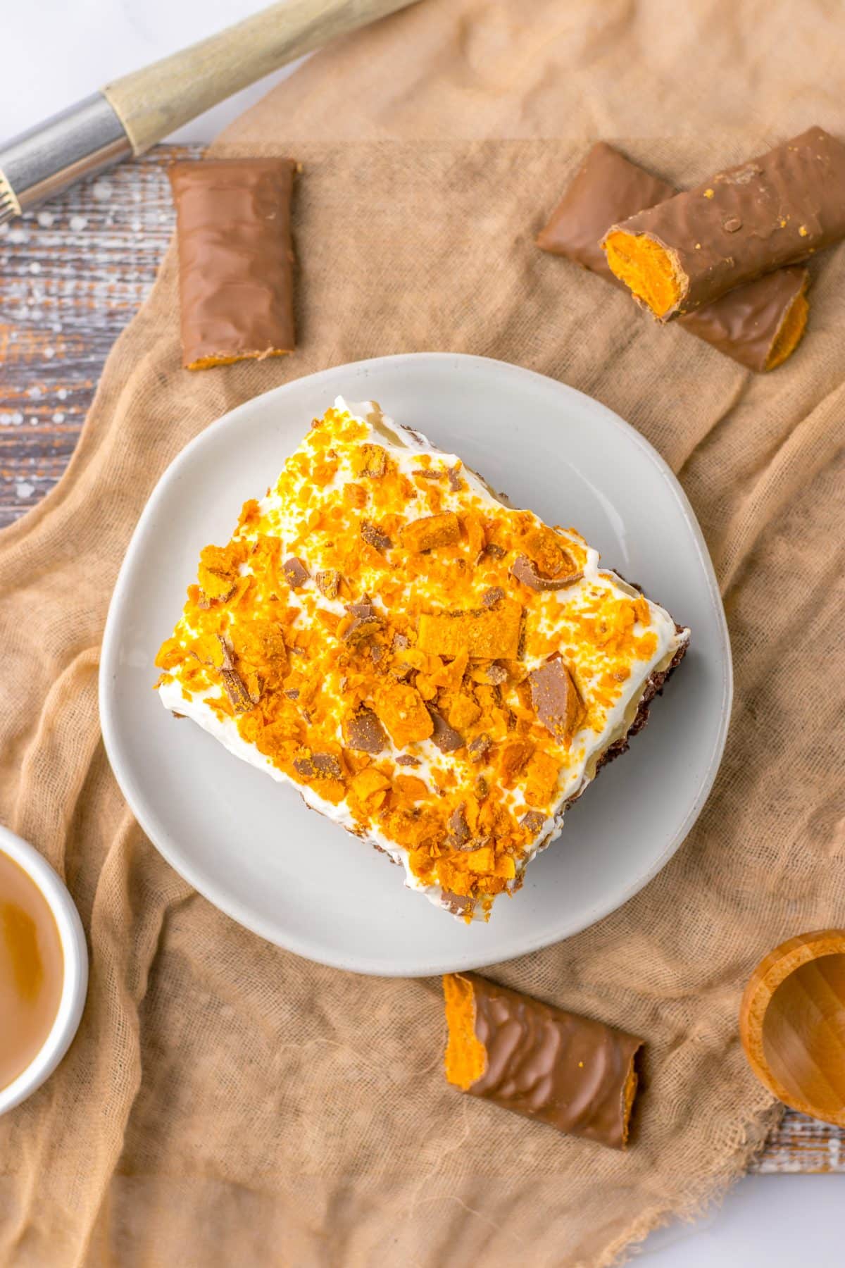 a slice of butterfinger poke cake on a small white plate