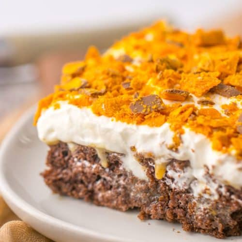 a slice of butterfinger poke cake on a small white plate