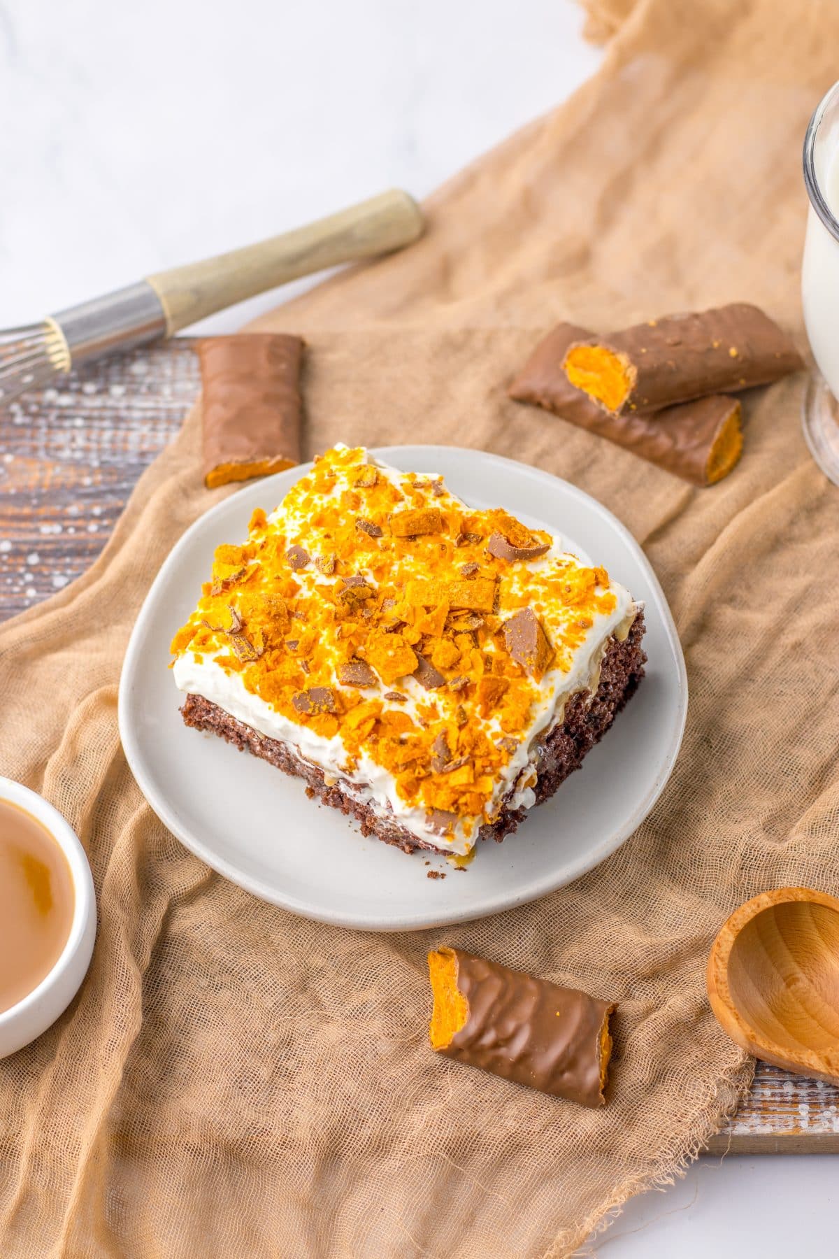 a slice of butterfinger poke cake on a small white plate