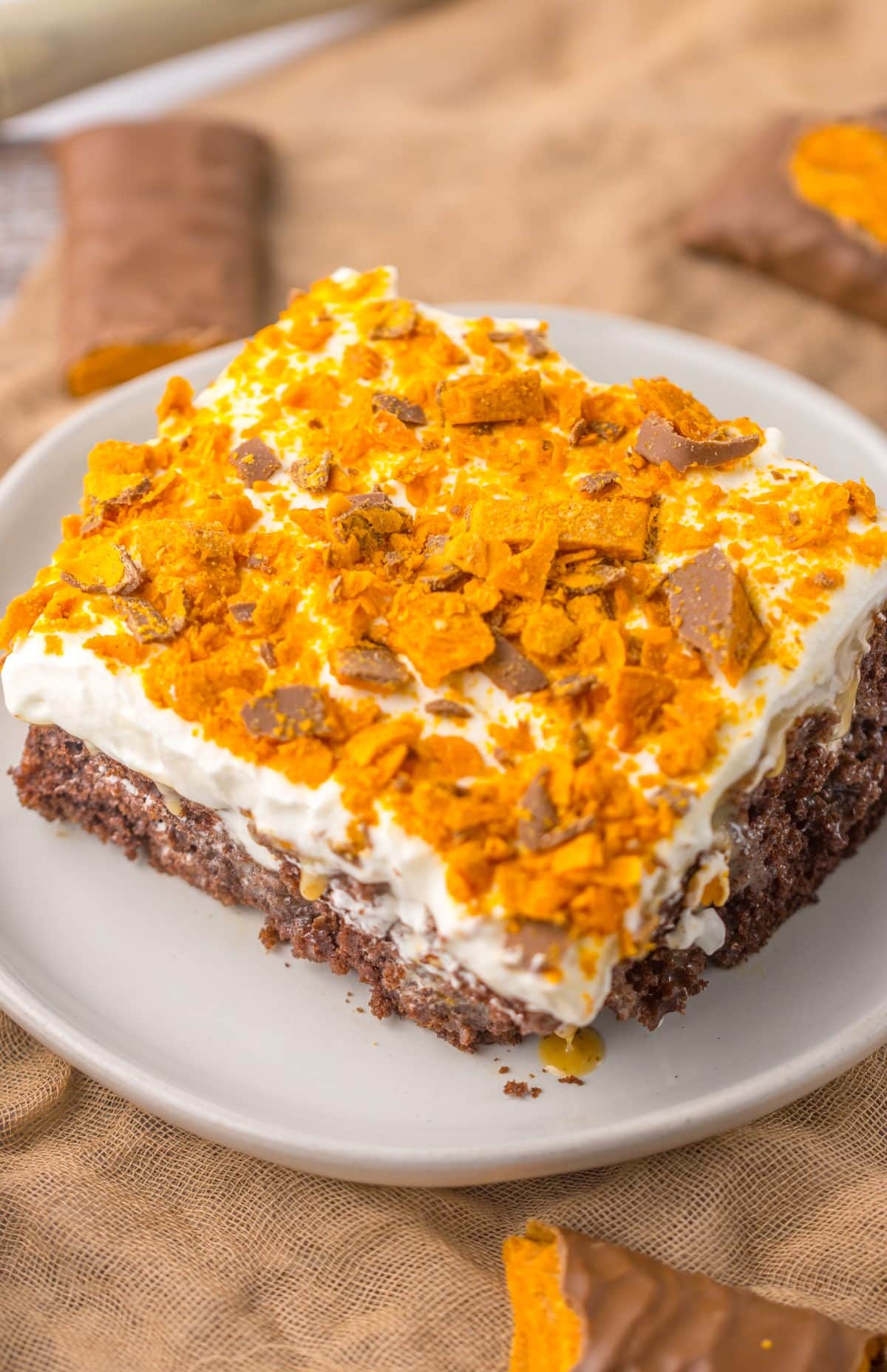 a slice of butterfinger poke cake on a small white plate