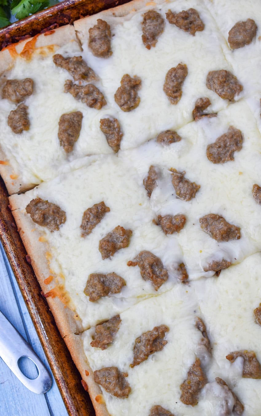 a sliced school breakfast pizza on a metal baking sheet