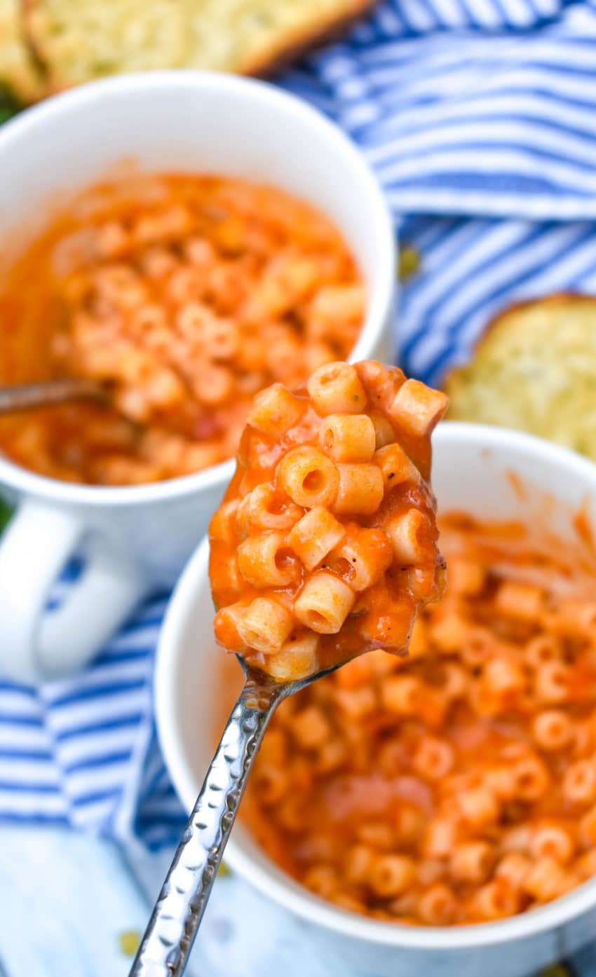 a silver spoon holding up a scoop of homemade microwave spaghettio's