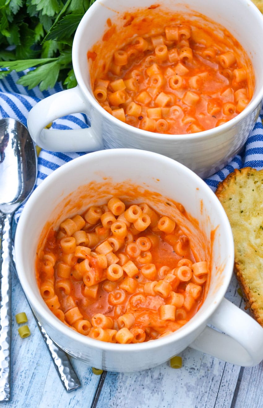 homemade microwave spaghettio's in two large white mugs