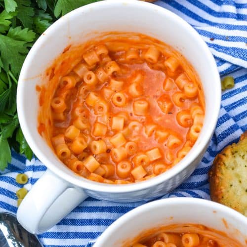 homemade microwave spaghettio's in two large white mugs