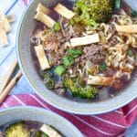 ground beef and broccoli ramen soup in two small gray bowls