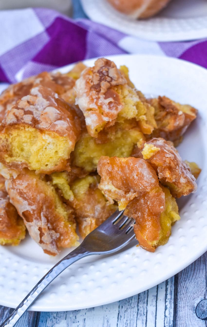 krispy kreme donut bread pudding on a small white plate with a silver fork resting on the side