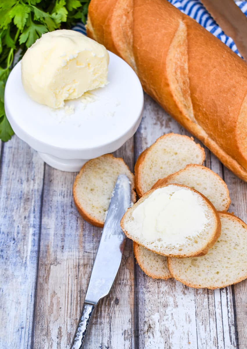 homemade mason jar butter spread on a slice of baguette bread on a wooden table