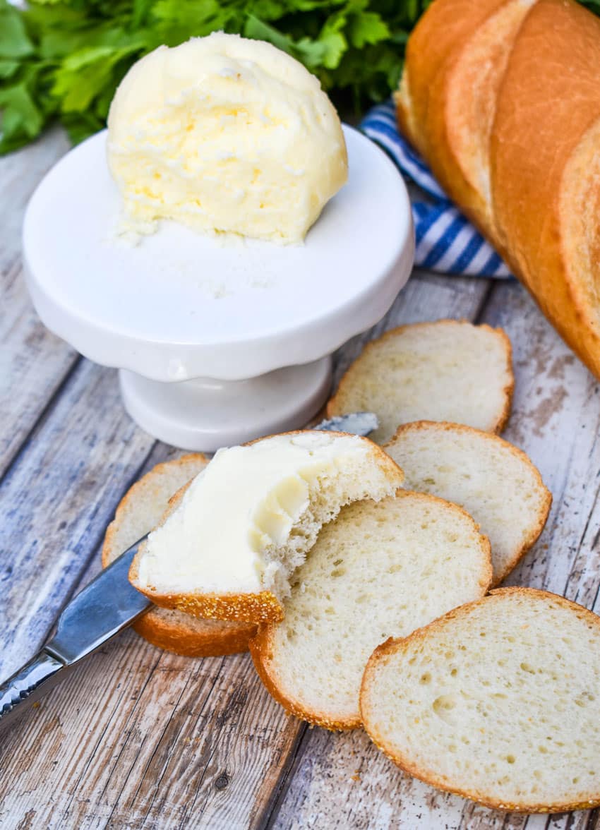 a bitten slice of baguette bread spread with easy mason jar butter from cream