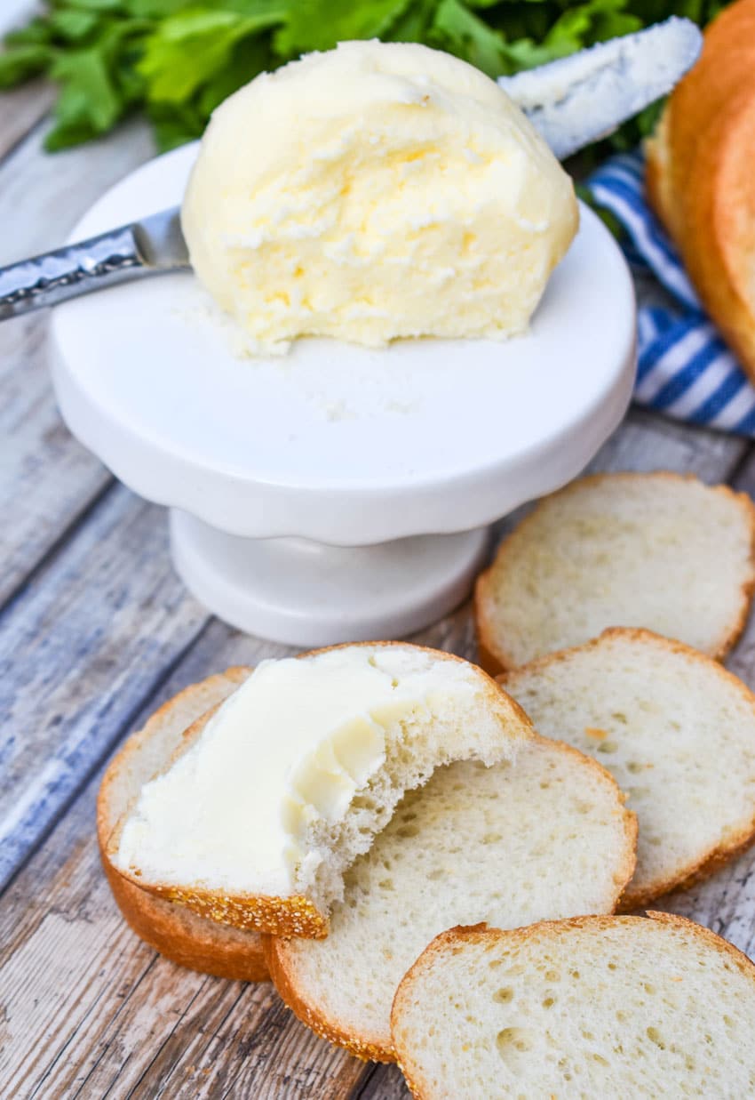 a bitten slice of baguette bread spread with easy mason jar butter from cream