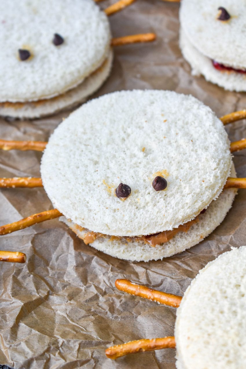 spider peanut butter and jelly sandwiches on a crinkled sheet of brown parchment paper