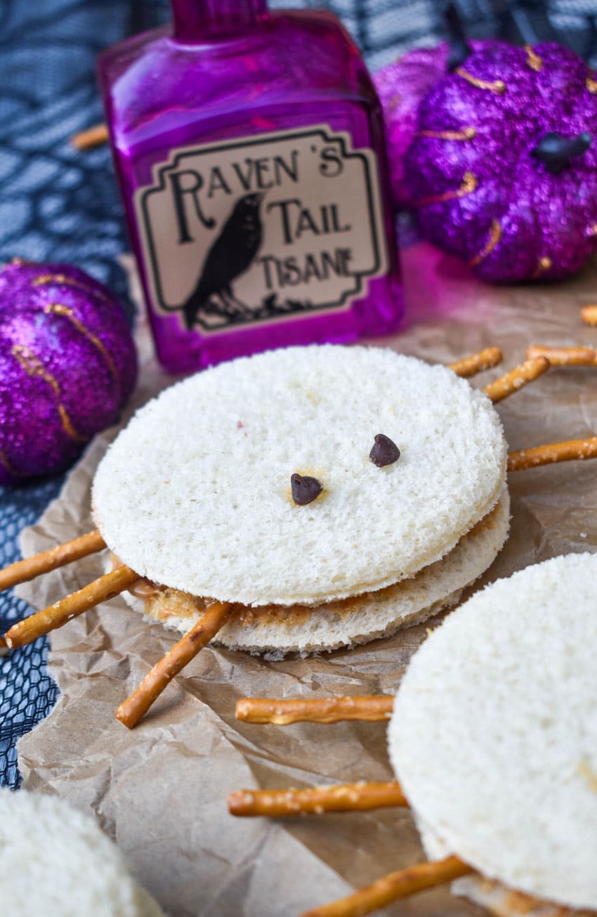 spider peanut butter and jelly sandwiches on a crinkled sheet of brown parchment paper