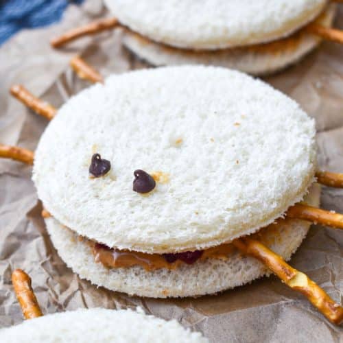 spider peanut butter and jelly sandwiches on a crinkled sheet of brown parchment paper