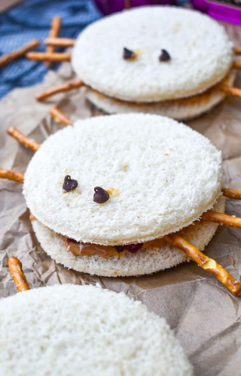 spider peanut butter and jelly sandwiches on a crinkled sheet of brown parchment paper