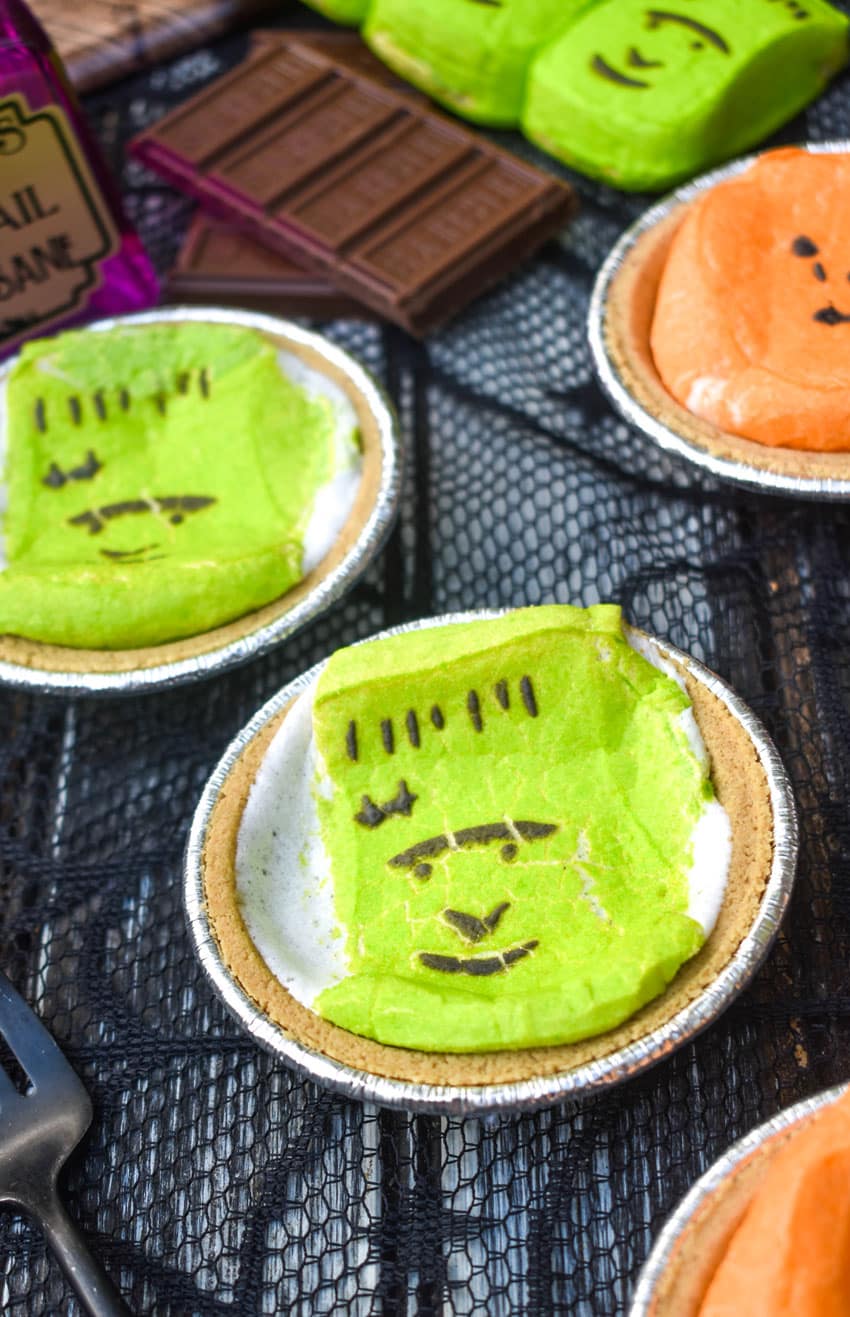 halloween mini s'more pies with hershey bars and green peeps in the background