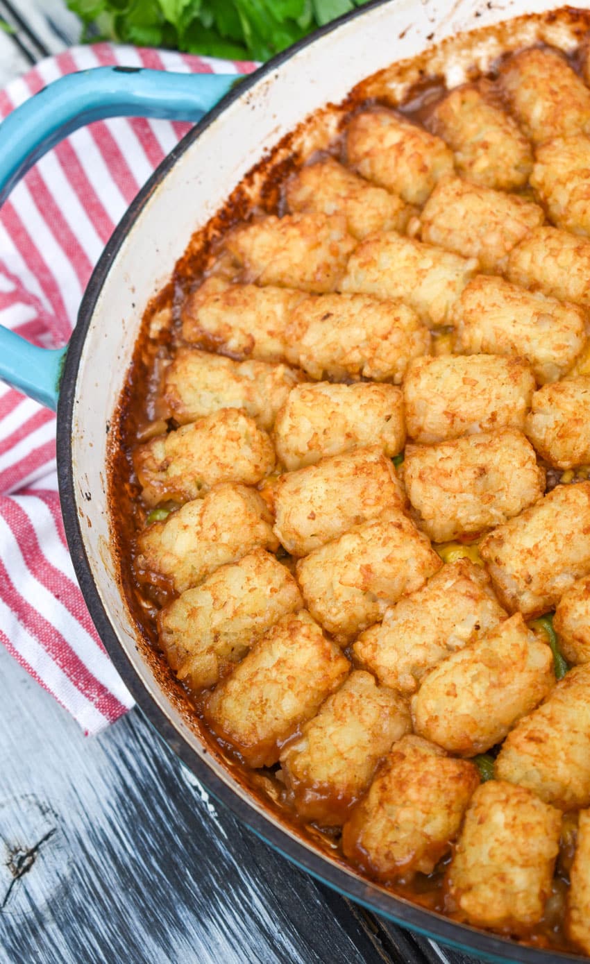 shepherds pie tater tot casserole in a blue enameled cast iron skillet