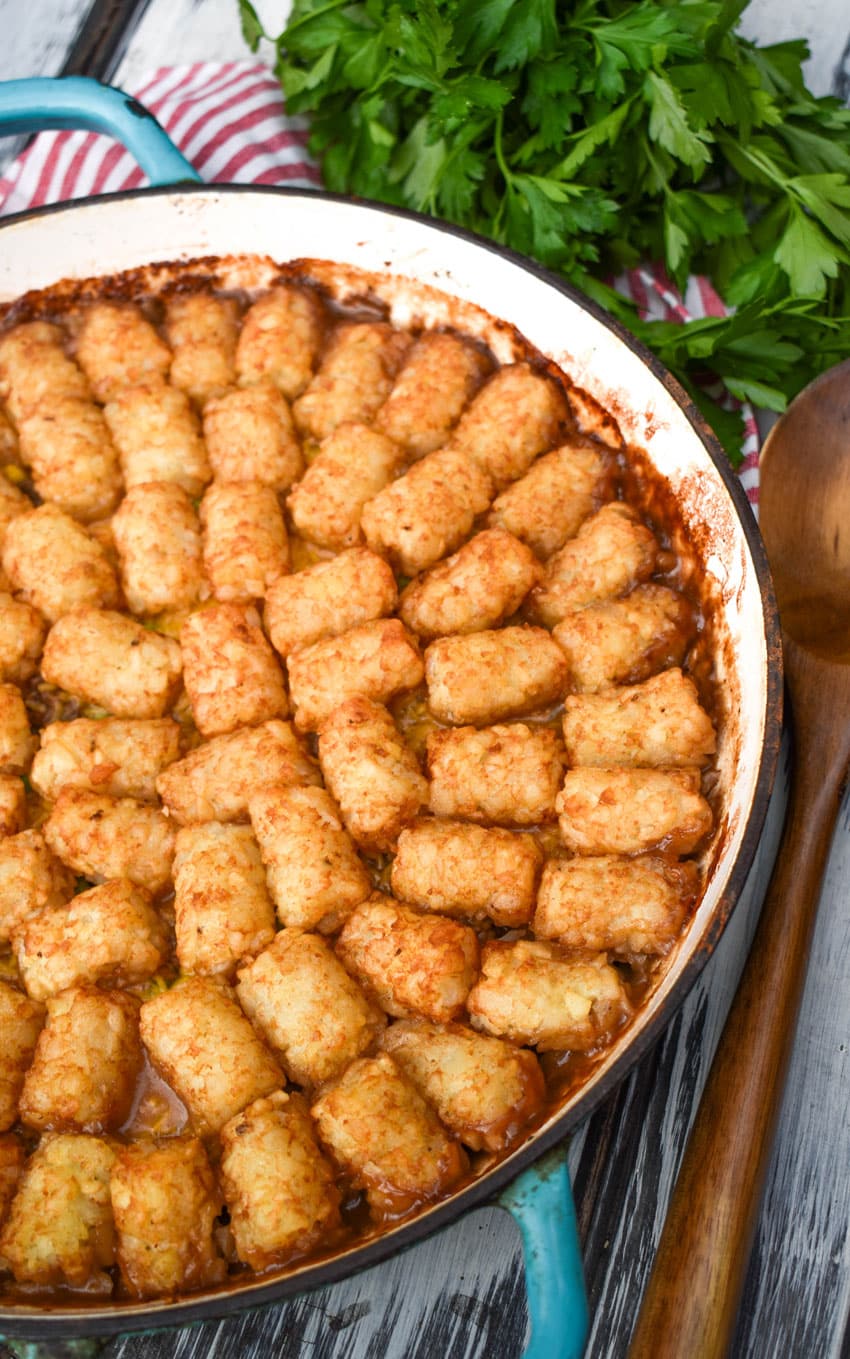shepherds pie tater tot casserole in a blue enameled cast iron skillet