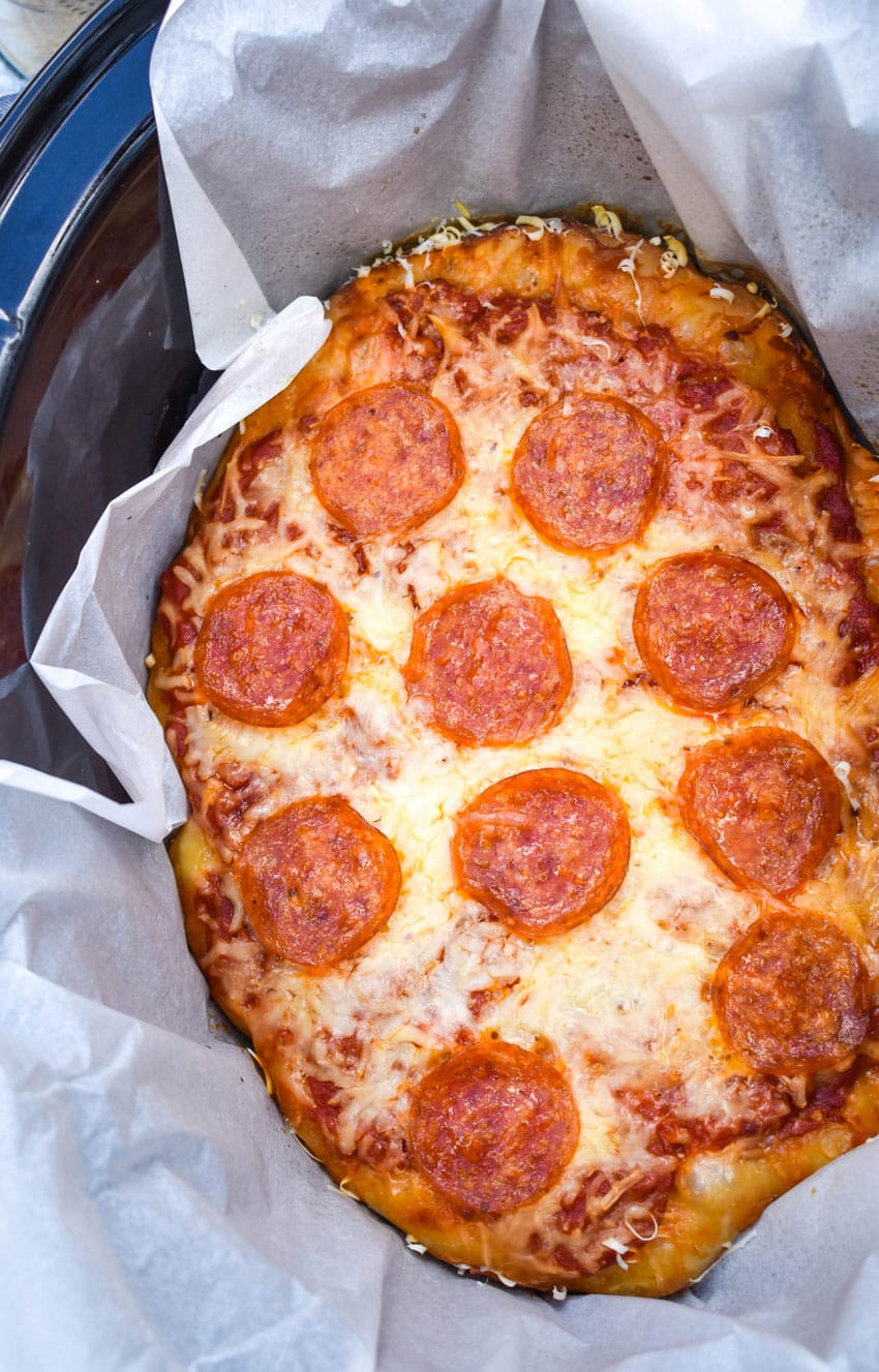 slow cooker pizza in a parchment paper lined crockpot