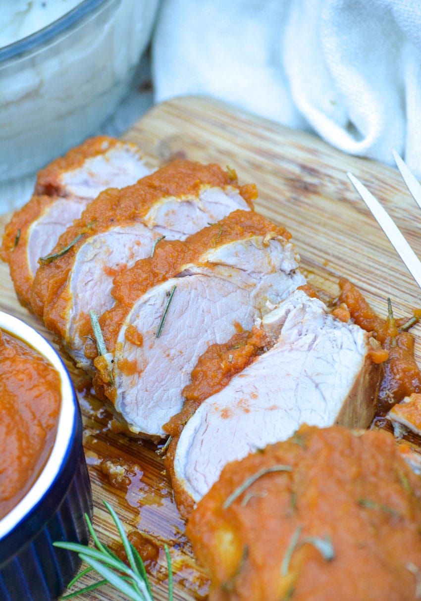 Pumpkin Butter Roasted Pork Tenderloin SLICES OF PUMPKIN BUTTER ROASTED PORK TENDERLOIN ON A WOODEN CUTTING BOARD