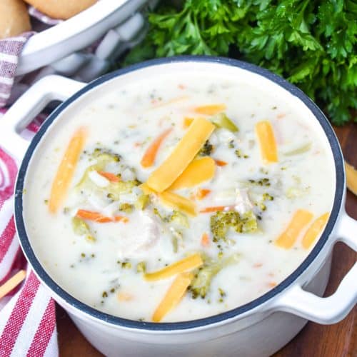 A BOWL OF CREAMY CHICKEN AND RICE A RONI SOUP ON A WOODEN CUTTING BOARD