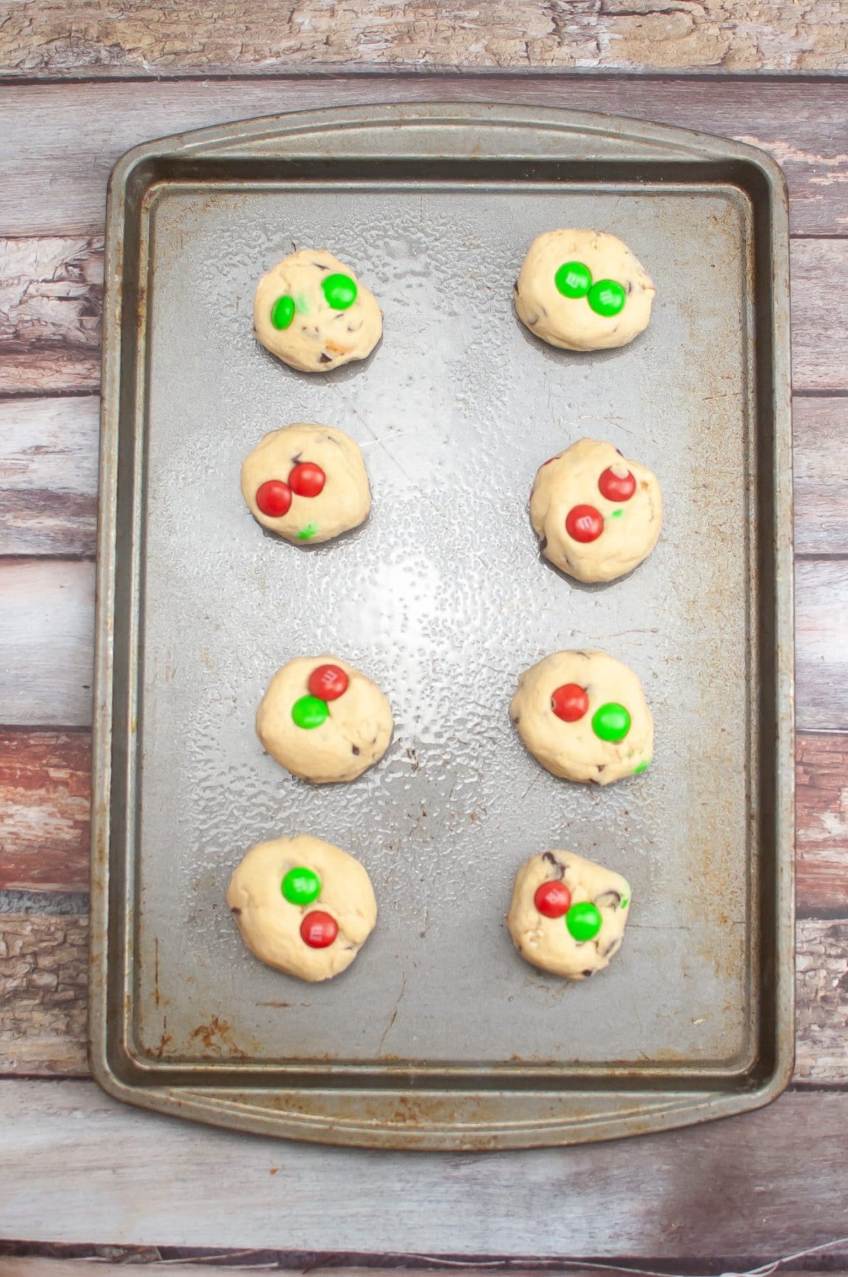 balls of christmas cookie dough on a metal baking sheet