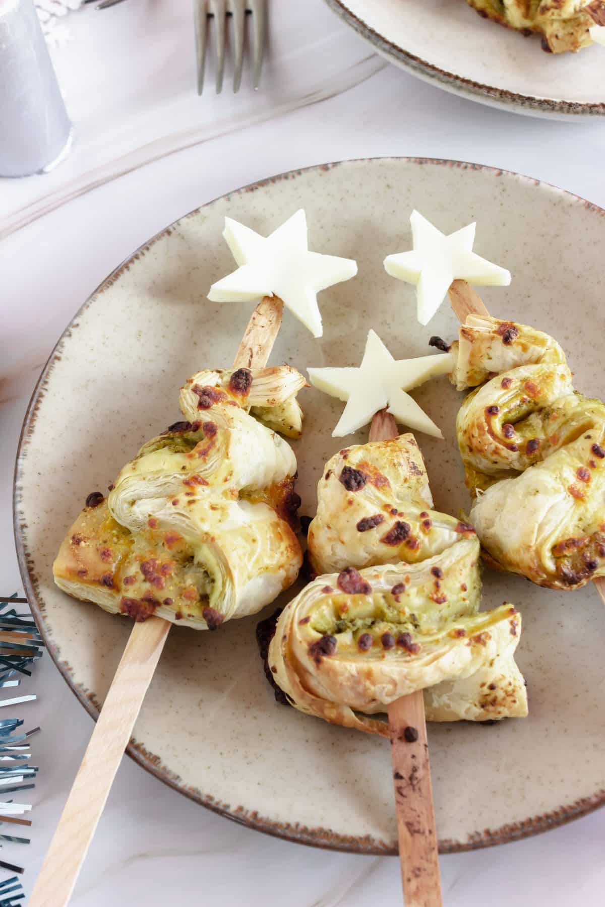 pesto puff pastry christmas trees on a white plate