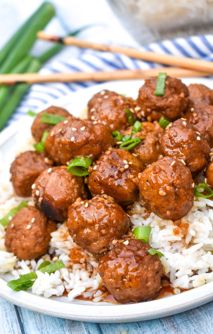 crockpot mongolian meatballs over steamed white rice on a white dinner plate