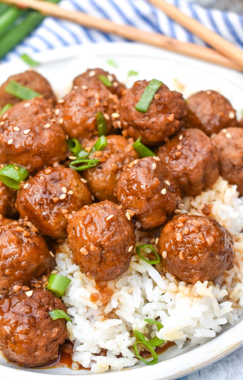 crockpot mongolian meatballs over steamed white rice on a white dinner plate