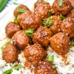 crockpot mongolian meatballs over steamed white rice on a white dinner plate