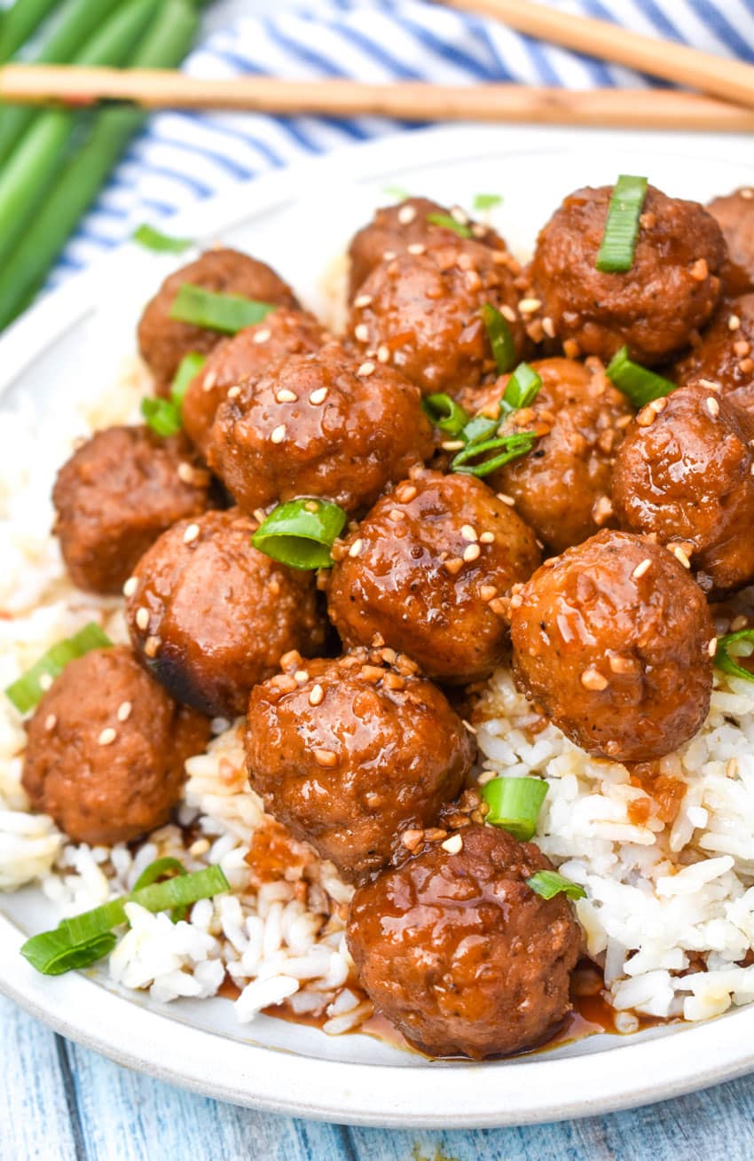 crockpot mongolian meatballs over steamed white rice on a white dinner plate