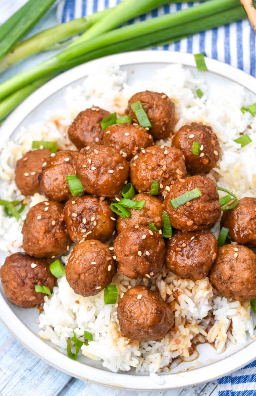 crockpot mongolian meatballs over steamed white rice on a white dinner plate